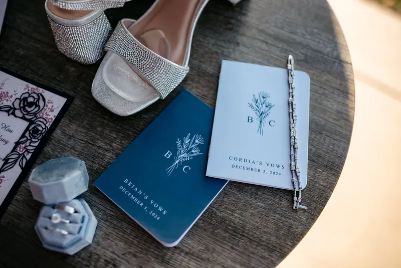 Wedding shoes, rings and invitations on a table